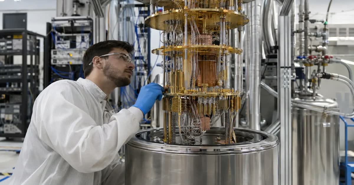 Technician inspecting a quantum computer’s cooling system in a laboratory.