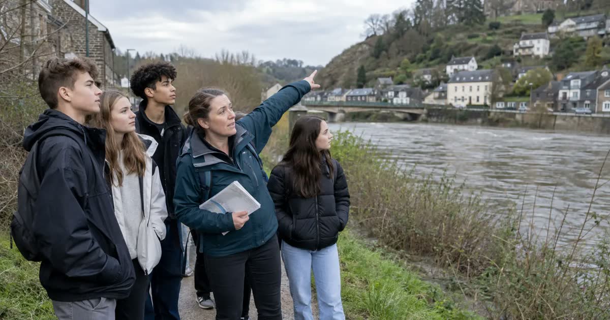 A teacher points out higher ground to students during a local riverside flood lesson.