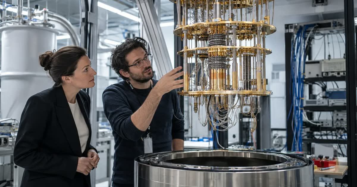 An engineer and a business visitor examine quantum computer cooling equipment in a laboratory.